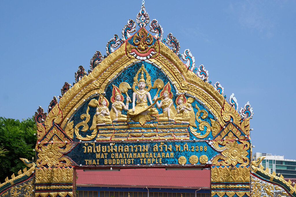 The ornate entrance of Wat Chaiyamangalaram, decorated in gold and blue